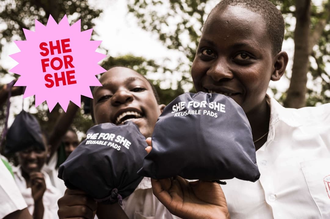 An inspiring image of girls holding reusable pads provided by the She for She initiative, which empowers girls and women in Africa by providing essential sanitary products.