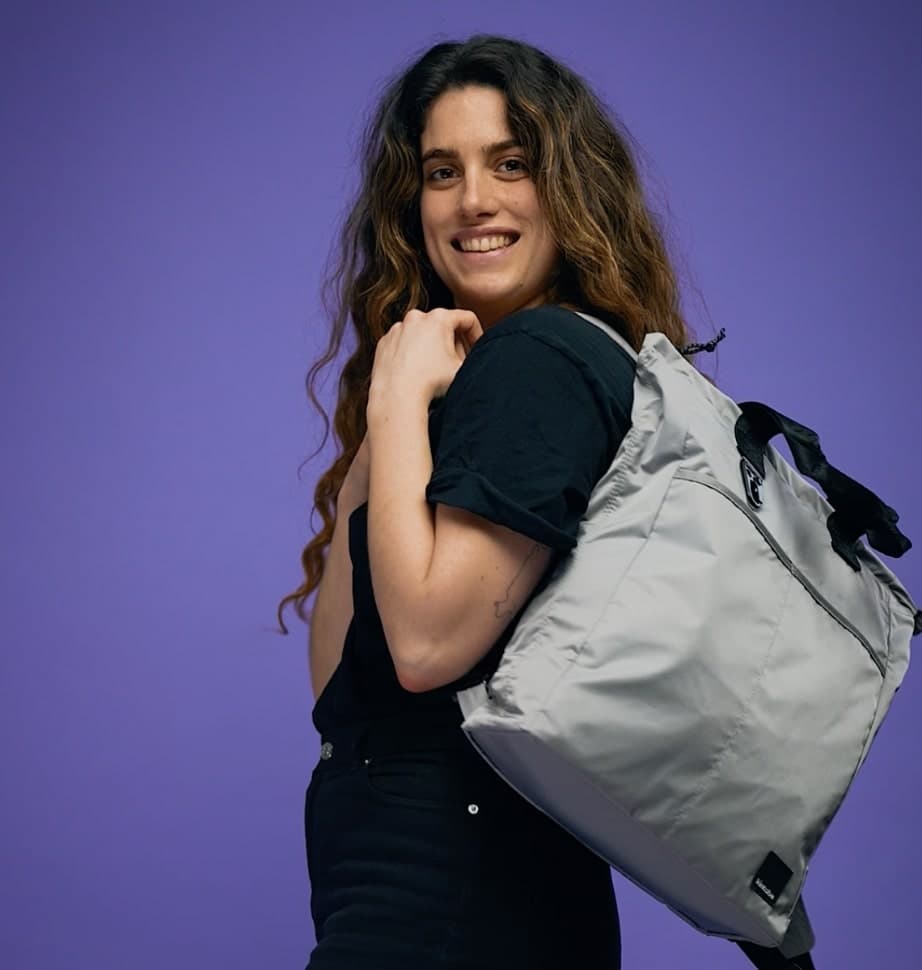 Coho Customer carrying a bag against a purple background