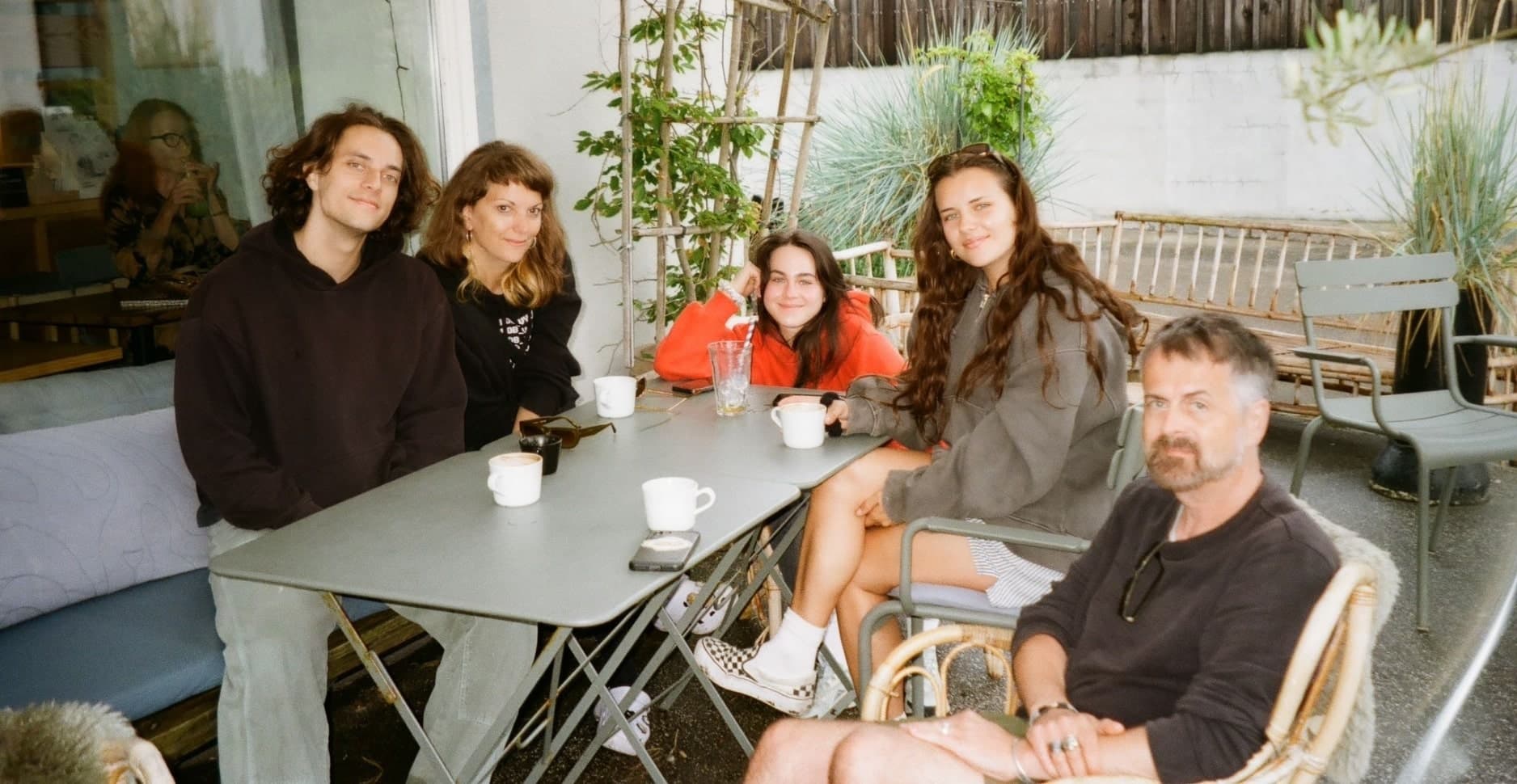 Lya with her boyfriend and work friends enjoying coffee at a table.