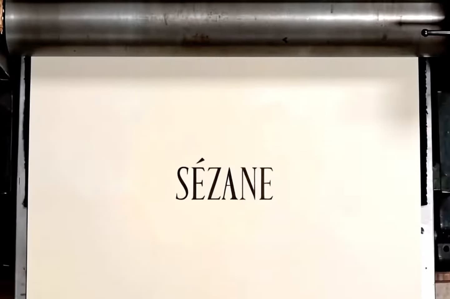 New condensed serif type Sézane logo printed on yellowing paper.